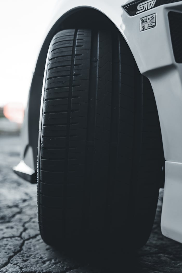 Close-up of a sleek sports car tire with selective focus, emphasizing texture.