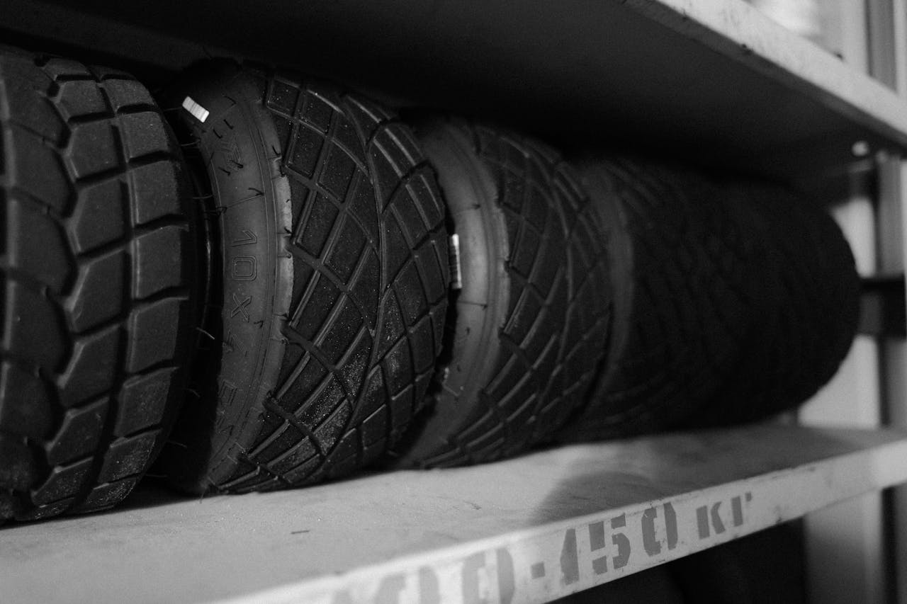 services-01 Monochrome photo of multiple tires arranged neatly on a shelf in a close-up shot.